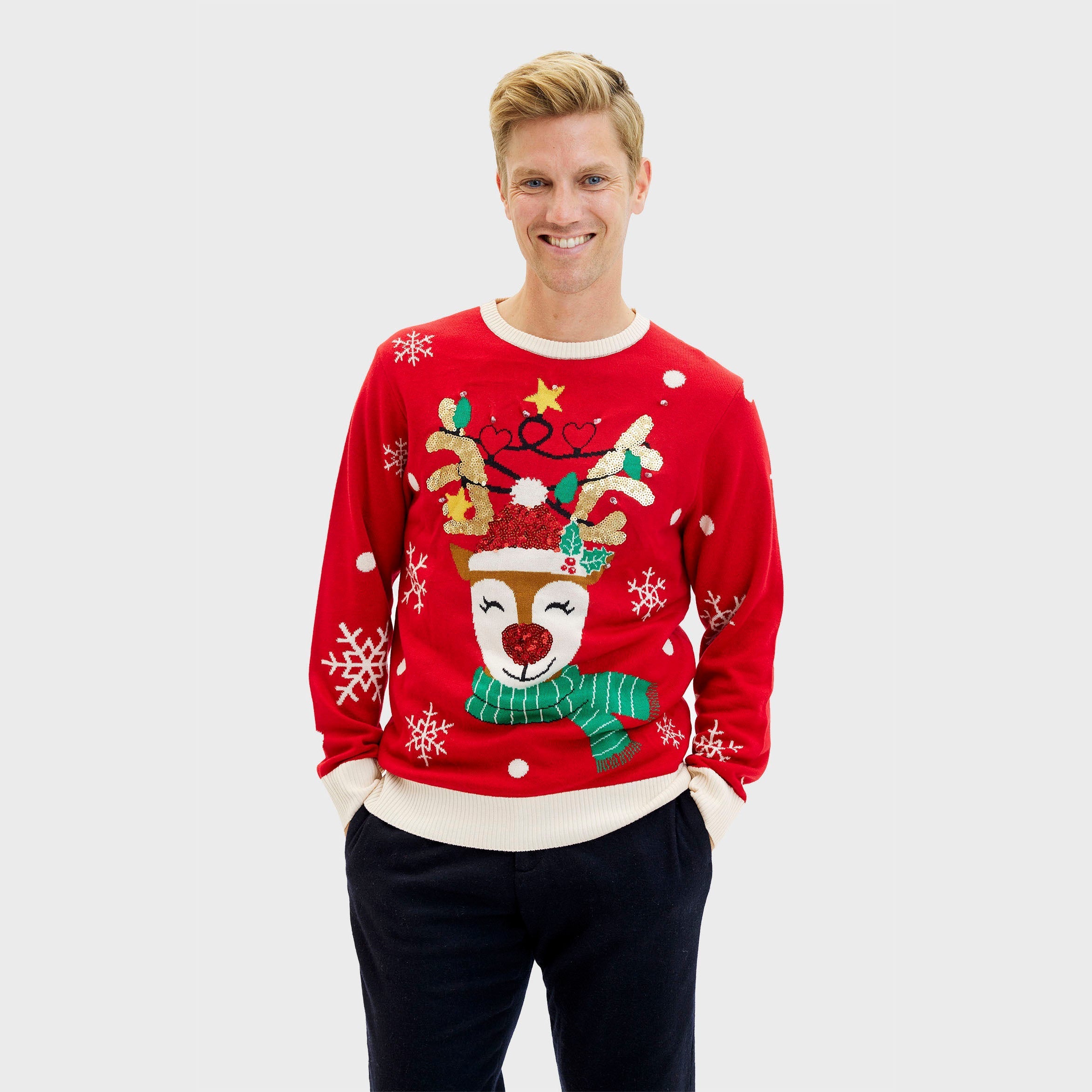 Roter Weihnachtspullover Herren mit Rentiermotiv, grüner Schal und weißen Schneeflocken.